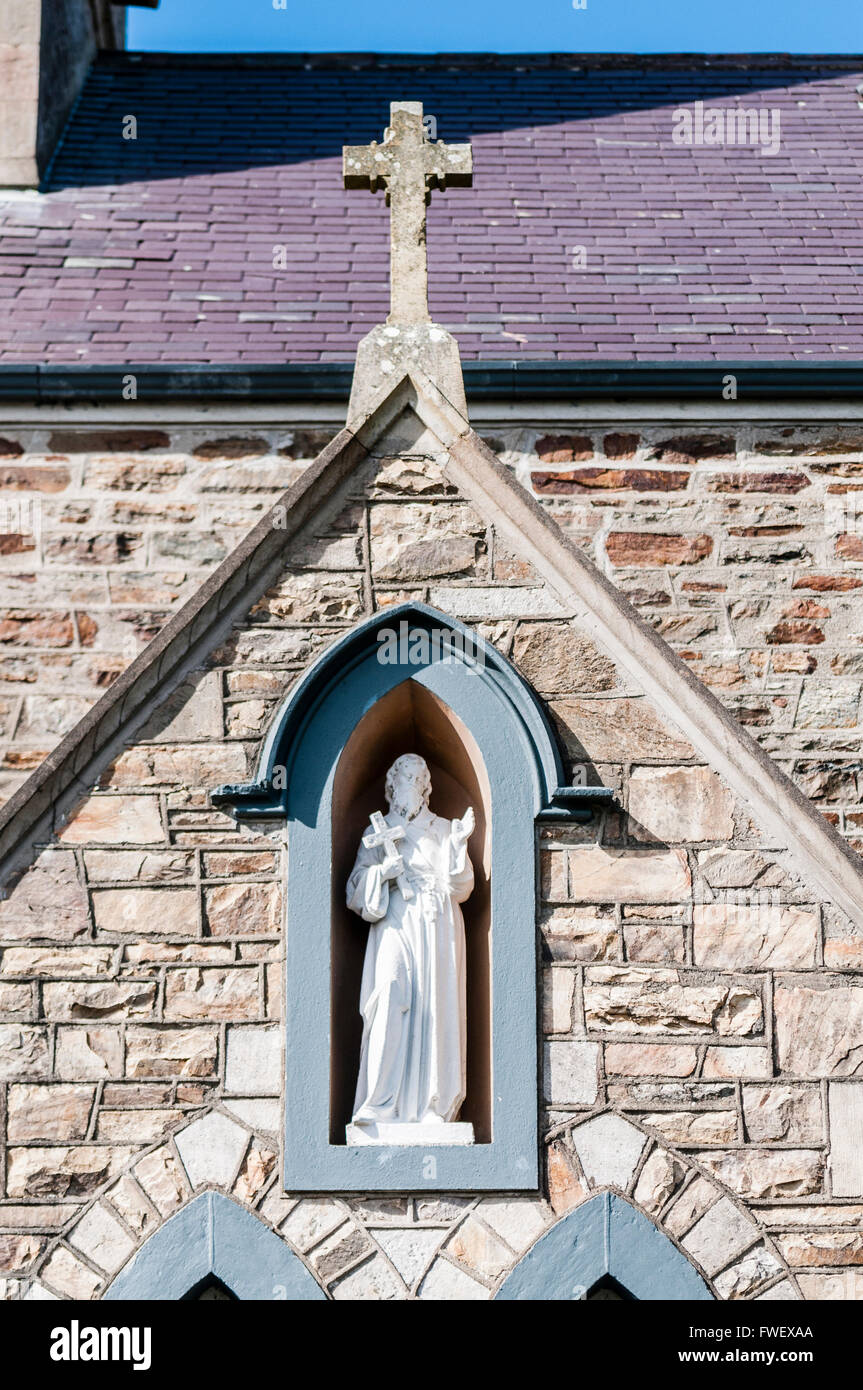 Statue de Saint Joseph tenant une croix dans une niche d'un mur de l'église. Banque D'Images