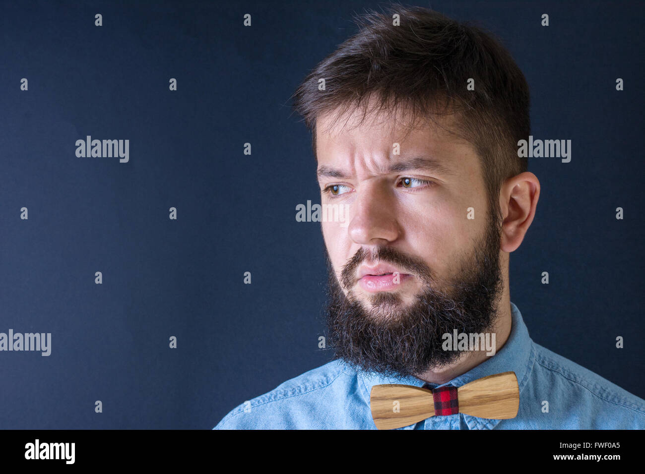 Homme barbu en colère dans une chemise bleue Banque D'Images