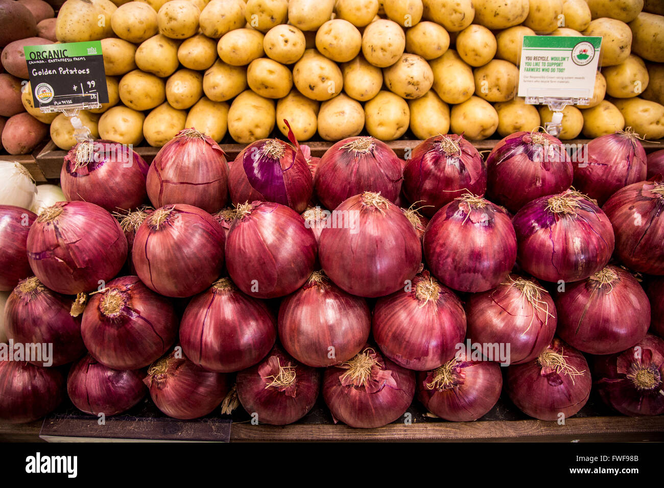 Un écran de pommes de terre biologiques et oignons rouges dans le d'un marché de produits agricoles. Banque D'Images