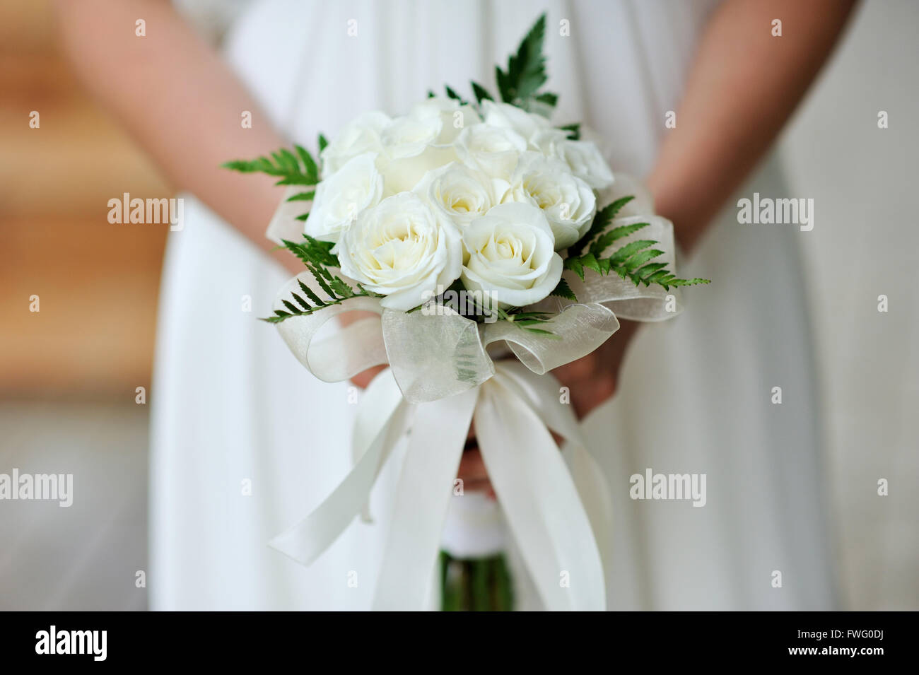 Bride holding bouquet de fleur de mariage de roses blanches Banque D'Images