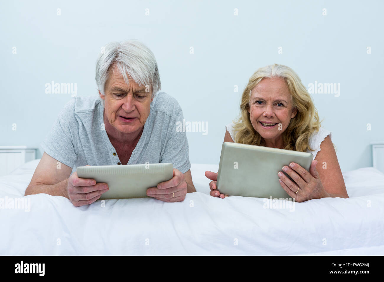 Couple using digital tablets tout en vous relaxant dans la chambre Banque D'Images