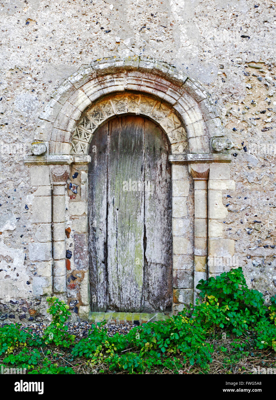 A l'entrée sur le côté nord de l'église de St Jean le Baptiste au Hellington, Norfolk, Angleterre, Royaume-Uni. Banque D'Images