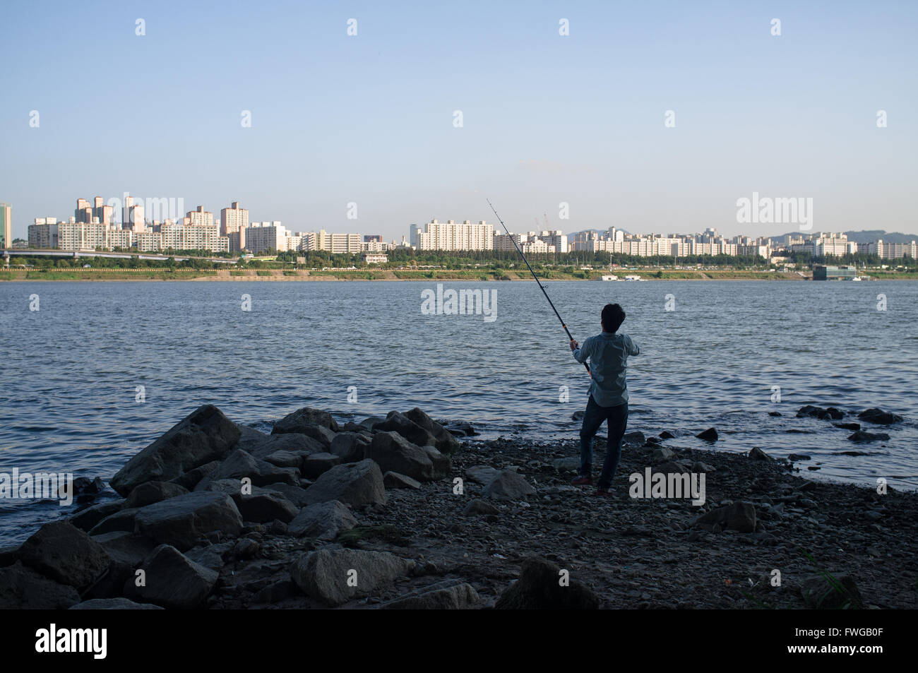 Un homme pêche dans la rivière Han à Séoul, Corée du Sud. Banque D'Images