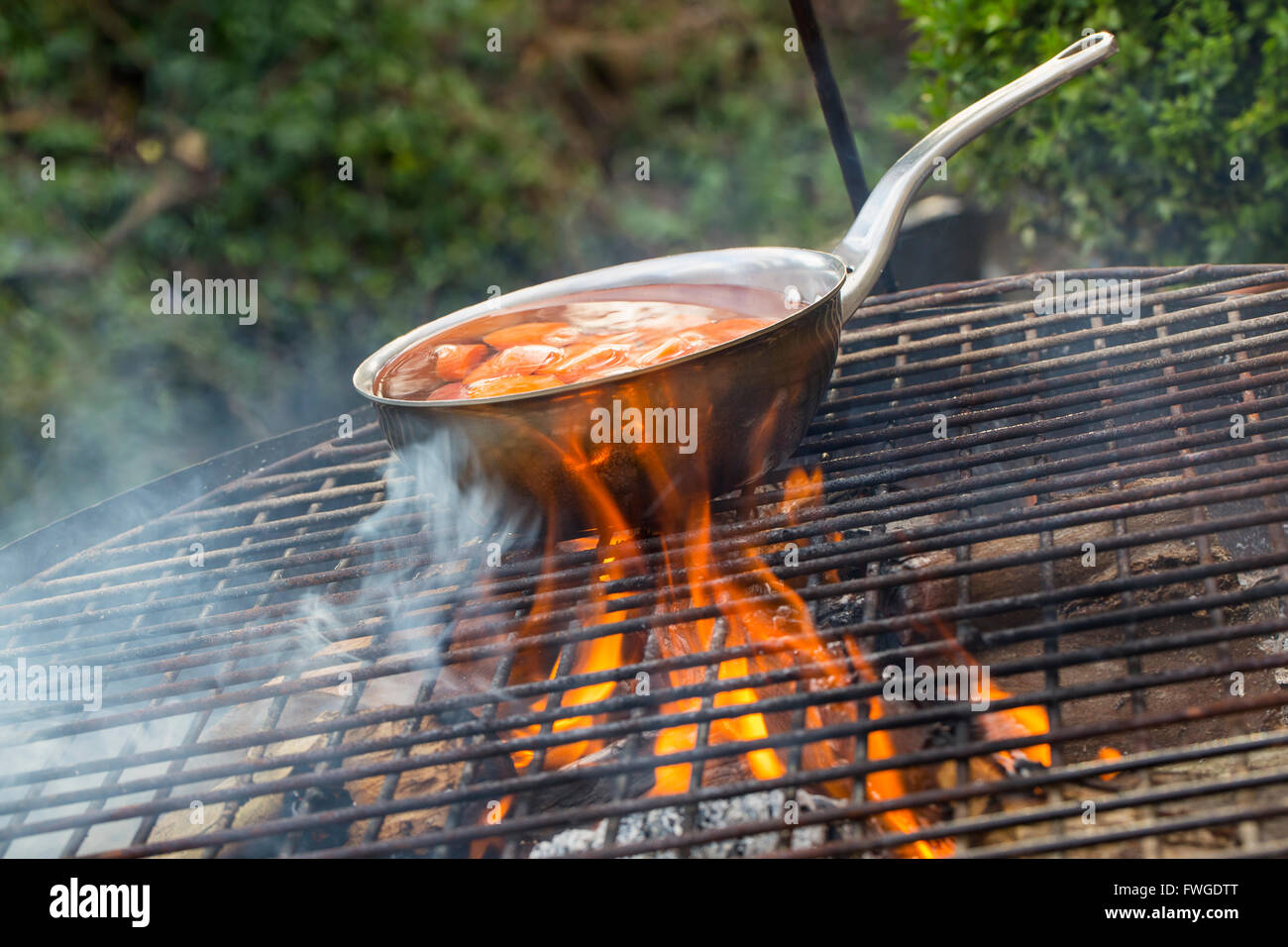 Une petite casserole avec les carottes en tranches sur un feu ouvert. Banque D'Images