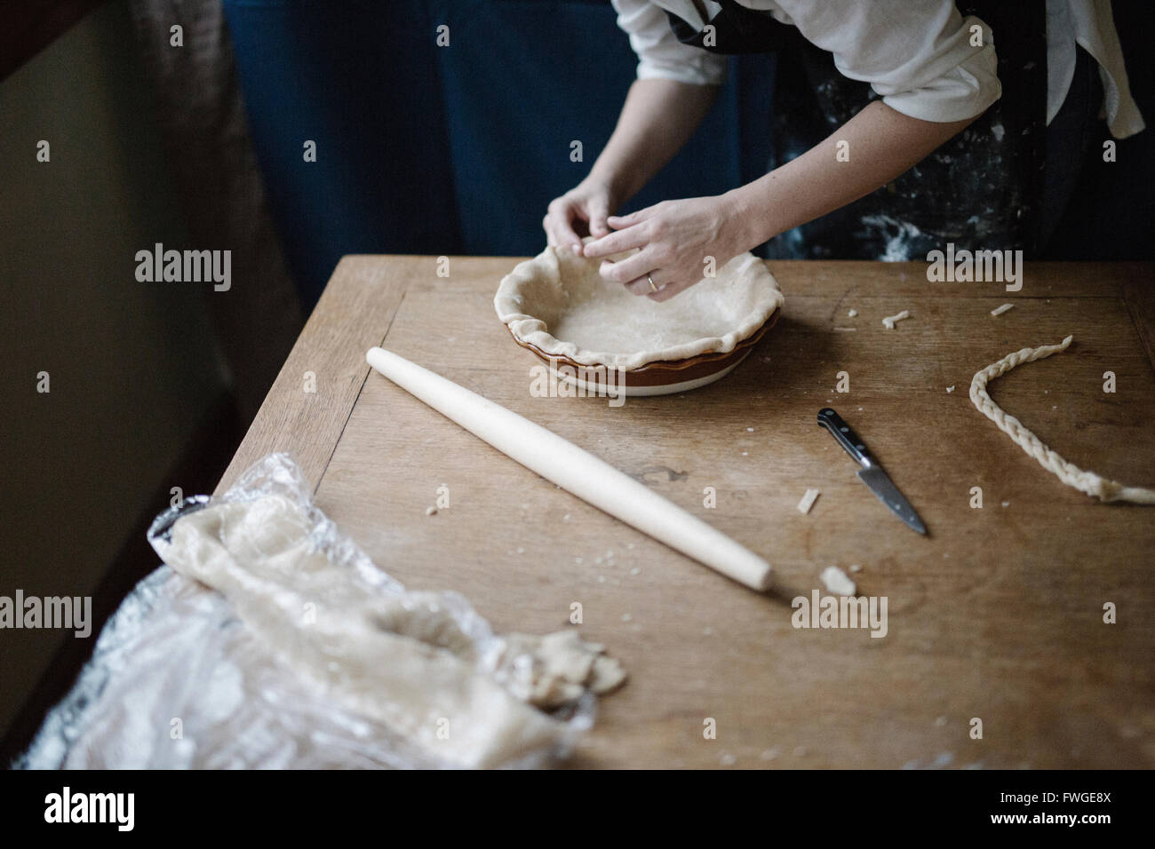 Une femme travaillant le lissage de la lisière d'un fond plat à tarte une doublure. Banque D'Images