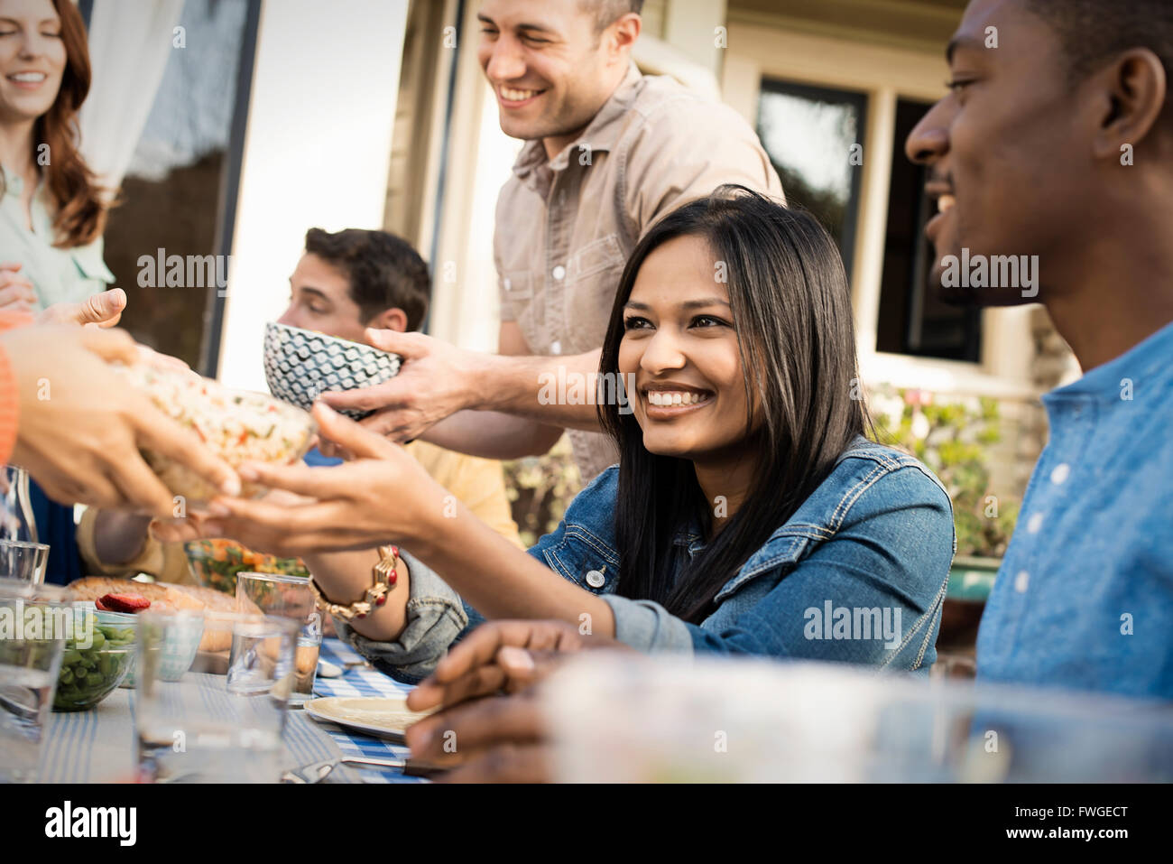 Autour d'une table d'amis, hommes et femmes de rire et de parler. Banque D'Images