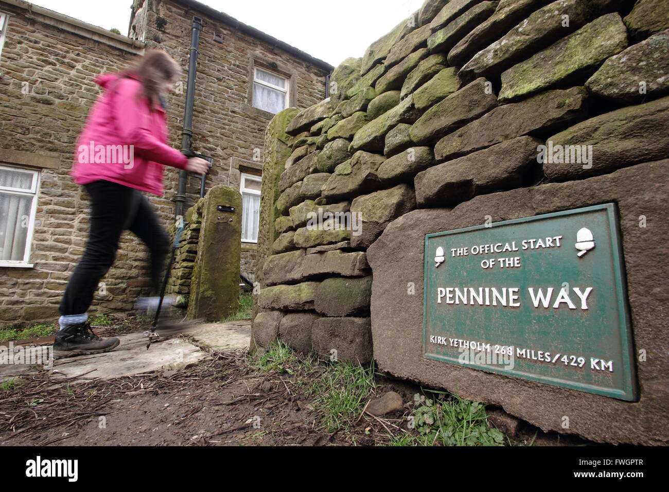 Une femelle walker passe le panneau au point de départ officiel du sentier national Pennine Way à Edale, Diistrict de pointe, UK Banque D'Images