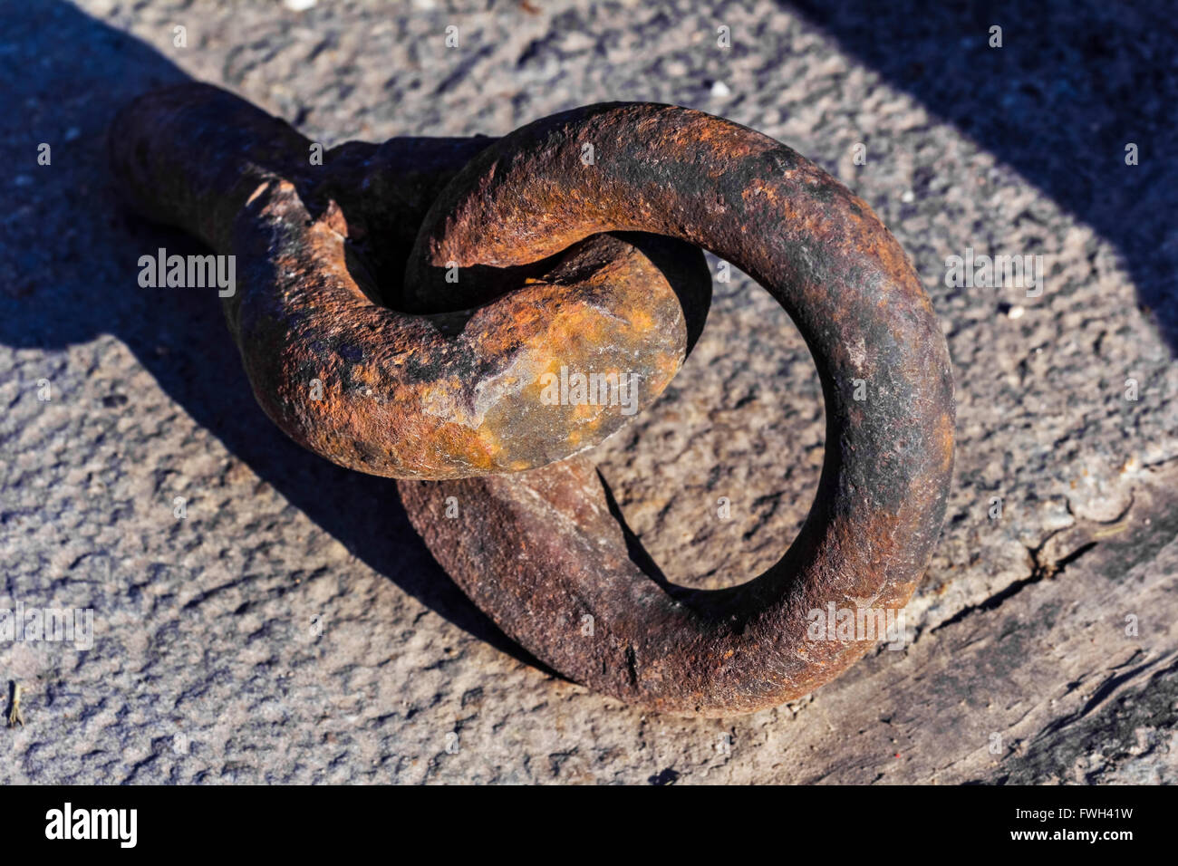 Ancien anneau rustique pour l'amarrage des bateaux à la journée ensoleillée sur le granit Banque D'Images