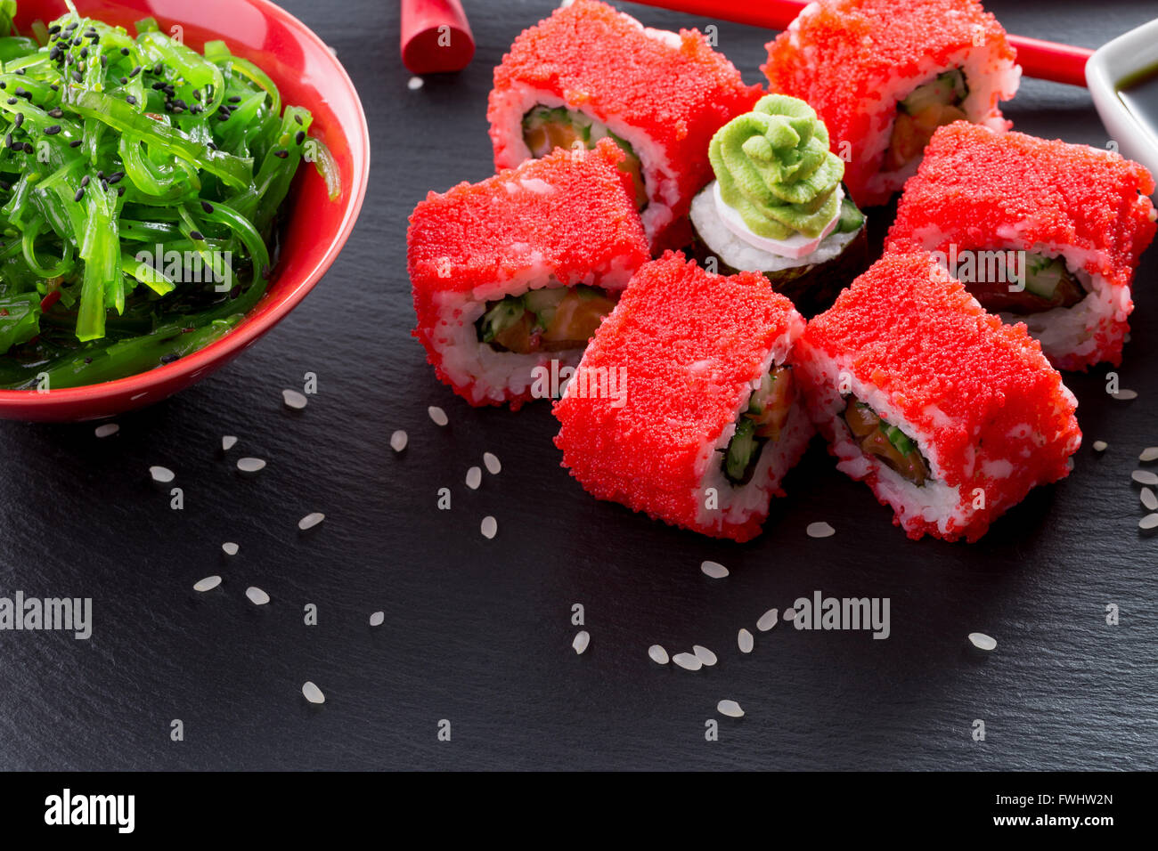 Rouleaux de sushi avec seasalad vert sur une table d'ardoise. Banque D'Images