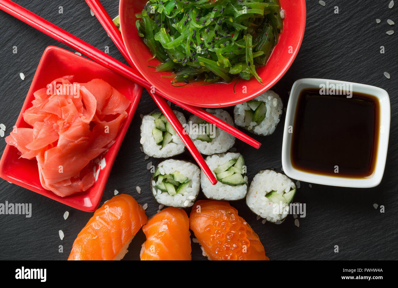 Rouleaux de sushi et salade de la mer avec le vert sur une table d'ardoise. Banque D'Images