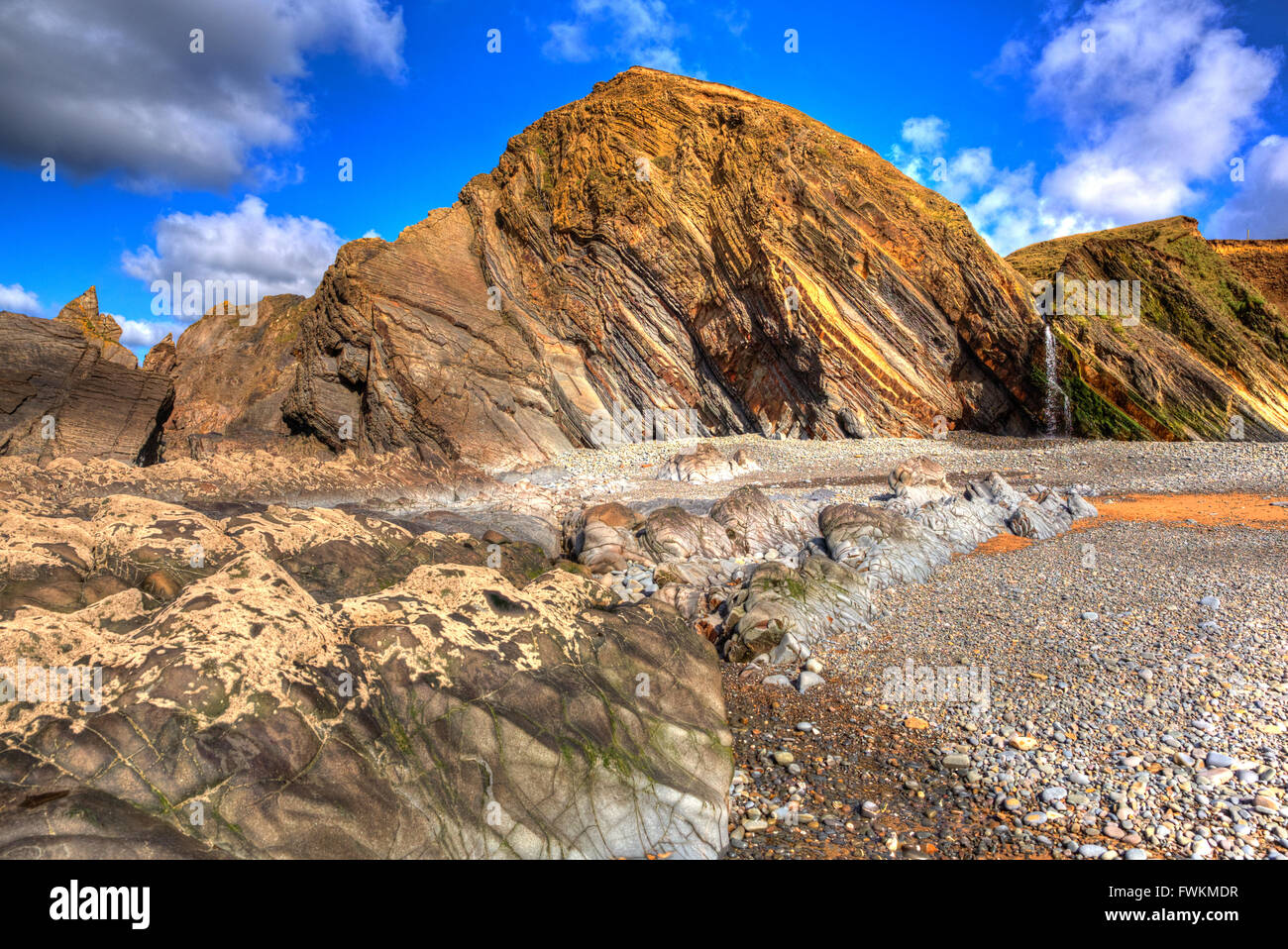 Sandymouth beach North Cornwall England UK beaux rochers avec des schémas inhabituels en HDR colorés avec cascade Banque D'Images