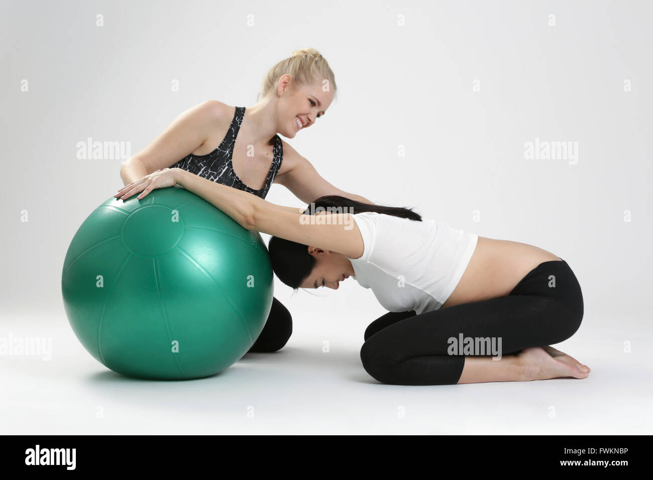 Femme enceinte faire l'exercice de remise en forme avec un entraîneur personnel Banque D'Images