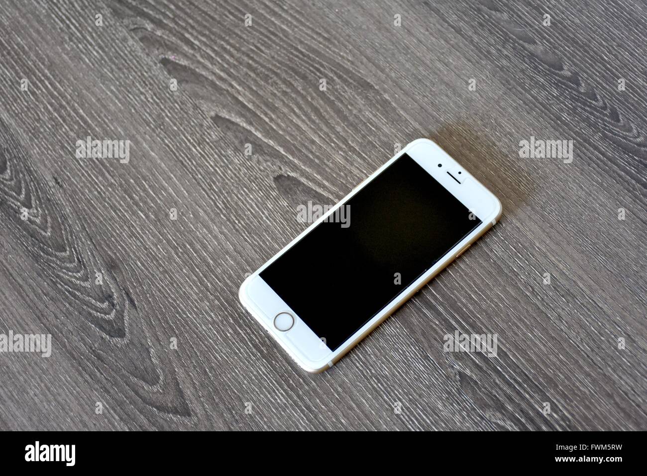 Un Apple iPhone 6s'affiche sur une surface en bois. Banque D'Images
