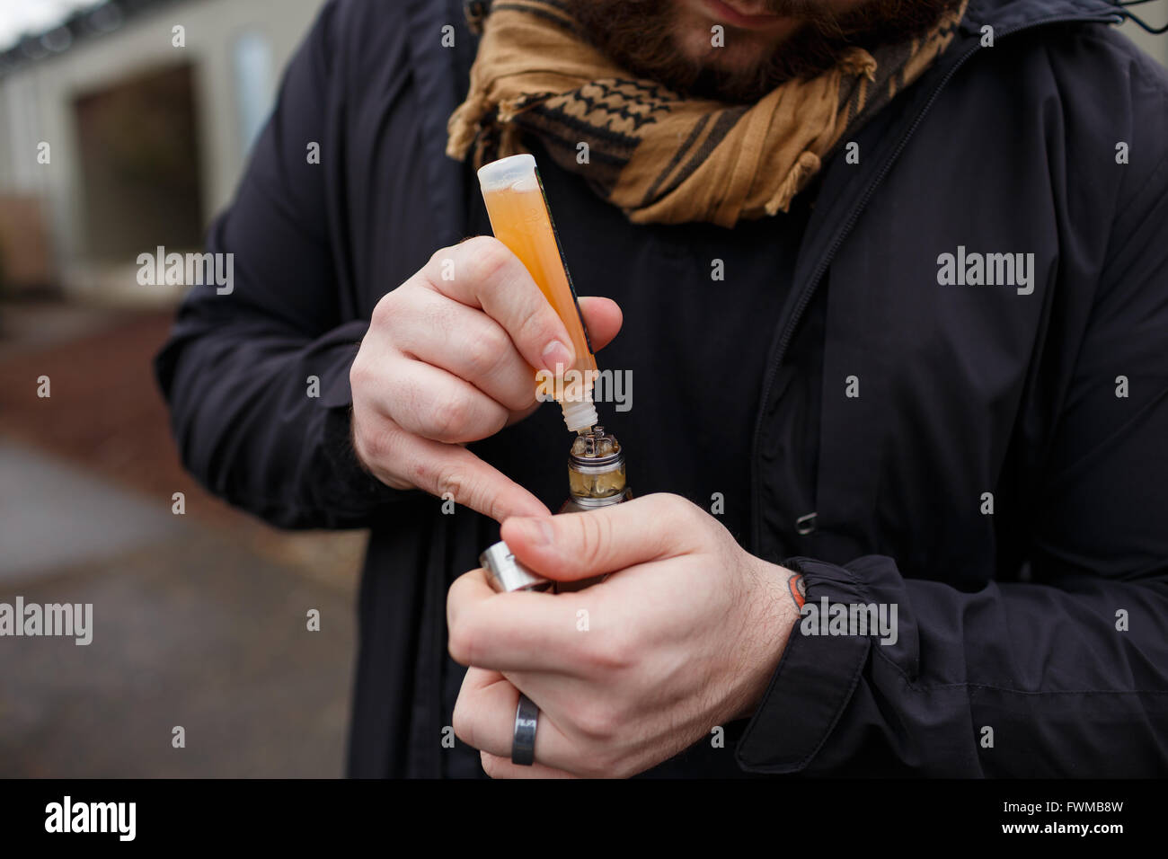 Urban lifestyle portrait d'un homme vaping dans un environnement urbain avec un appareil. mod vape Banque D'Images