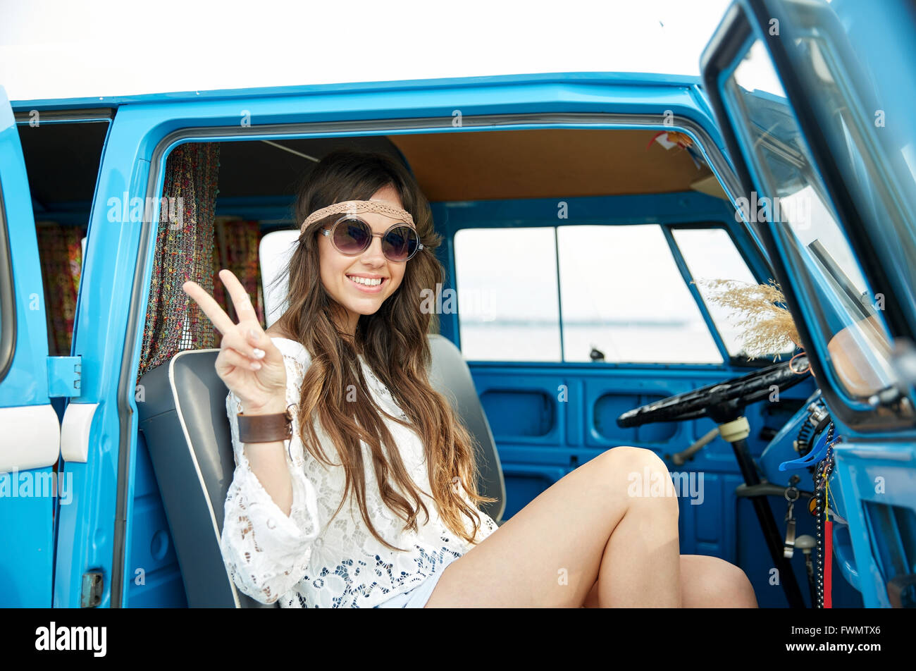 Femme hippie heureux montrant la paix en voiture fourgonnette Banque D'Images