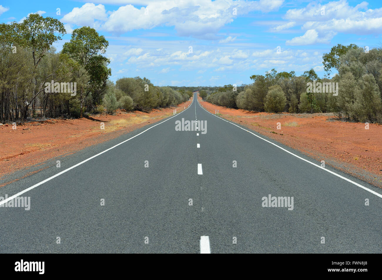 Australian Outback deux voies avec terre rouge, bleu ciel et nuages. Photo Chris Ison. Banque D'Images