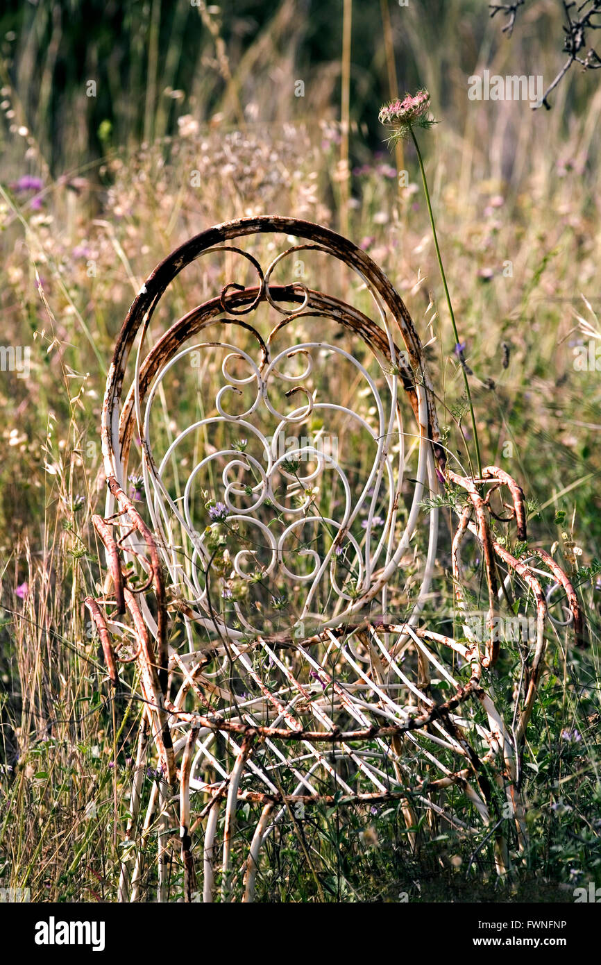 Ancien fauteuil de jardin abandonné dans l'herbe haute à l'ancienne métal rouillé rouille chaise rustique verticale longue herbe Jack Cox Banque D'Images