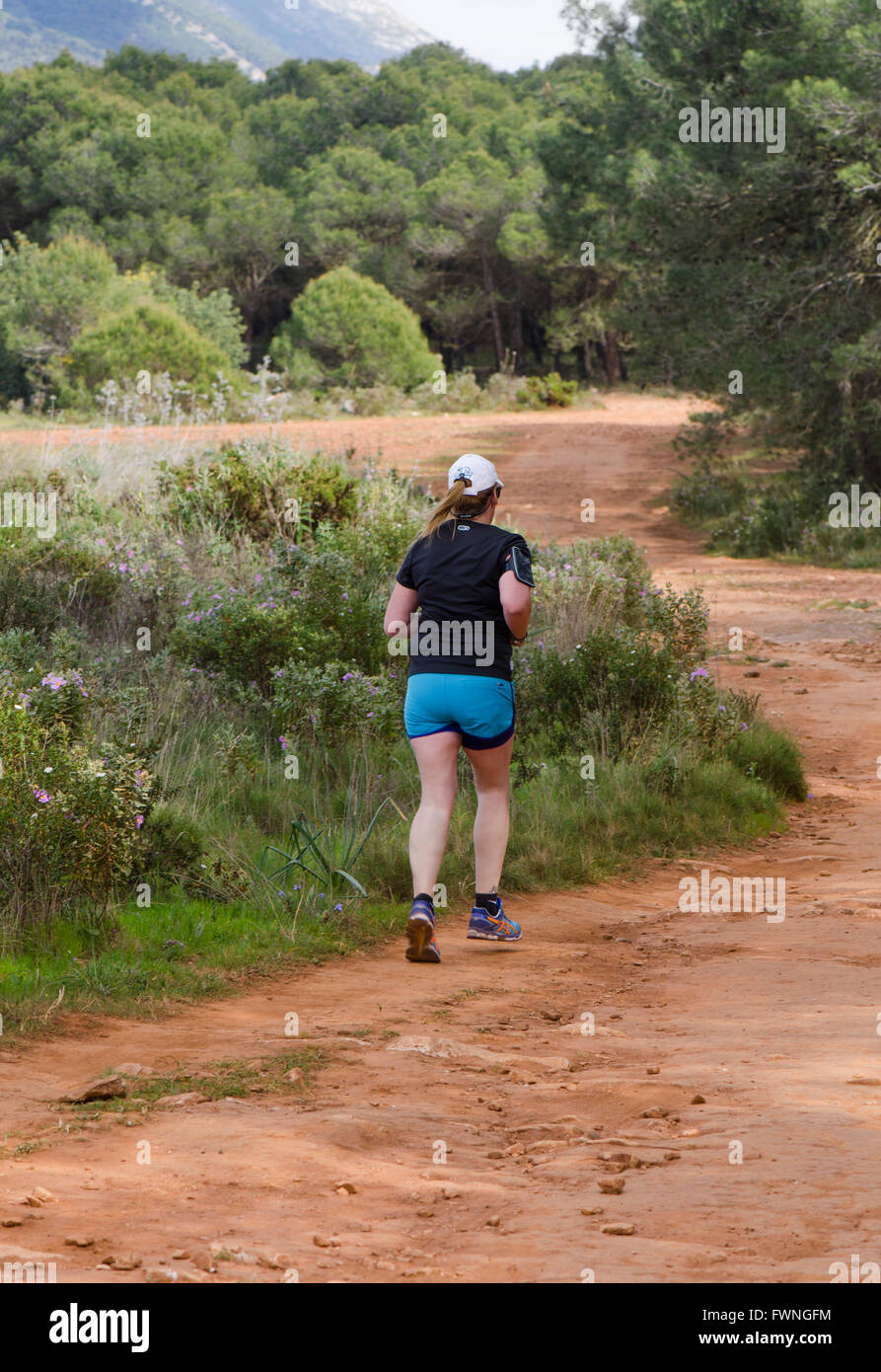 Young woman jogging dans la nature, forêt de pins, l'Andalousie, espagne. Banque D'Images