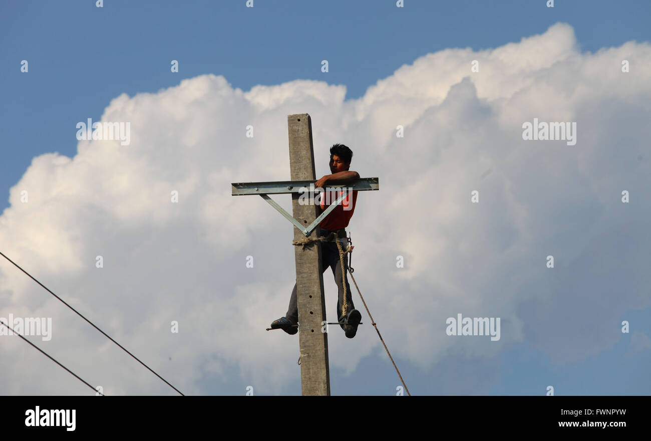 Kathmandu, Népal. 6ème apr 2016. Un travailleur définit des fils électriques sur un poteau béton nouvellement installé à Khokana village de Kathmandu, Népal, le 6 avril 2016. © Sunil Sharma/Xinhua/Alamy Live News Banque D'Images