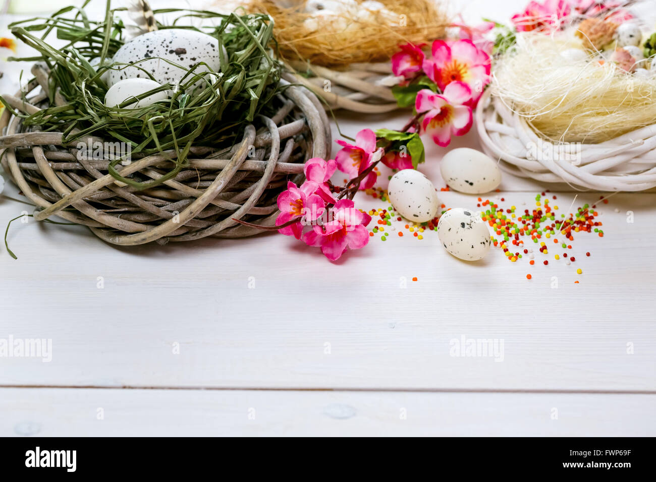 Arrière-plan de pâques avec des fleurs et des nids avec des oeufs sur le livre blanc panneaux peints. espace libre pour le texte Banque D'Images Arrière-plan de pâques avec des fleurs et des nids avec des oeufs sur le livre blanc panneaux peints. espace libre pour le texte Banque D'Images