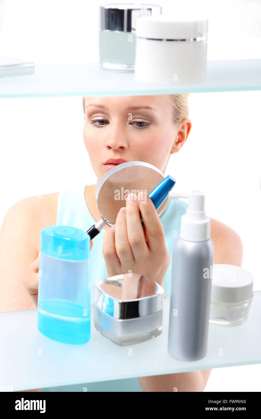 Une femme se dresse à l'étagère et client sélectionne des produits cosmétiques. Banque D'Images