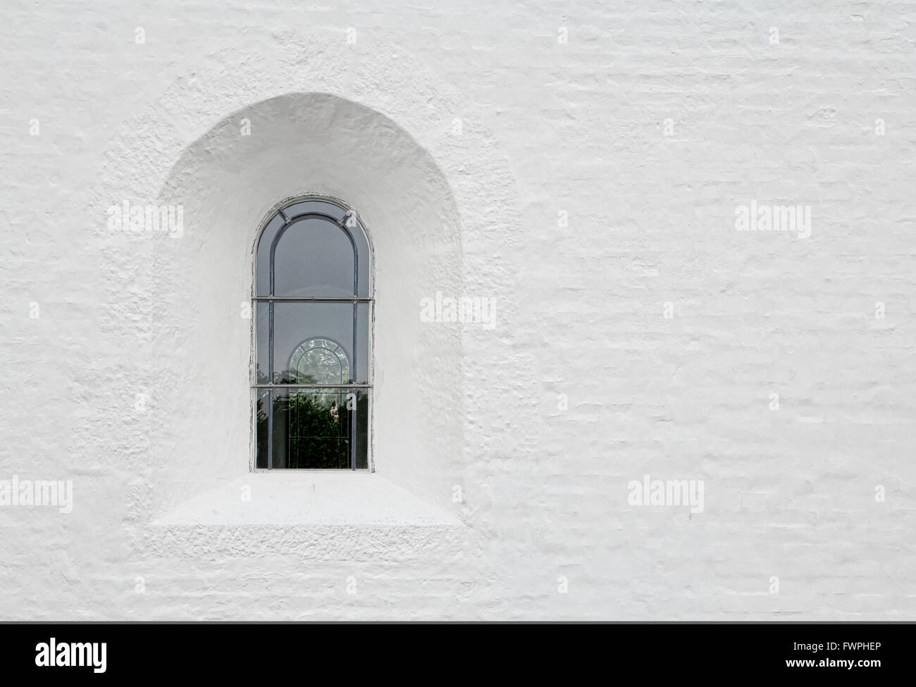 Au plomb dans une fenêtre arquée église blanche wall Banque D'Images