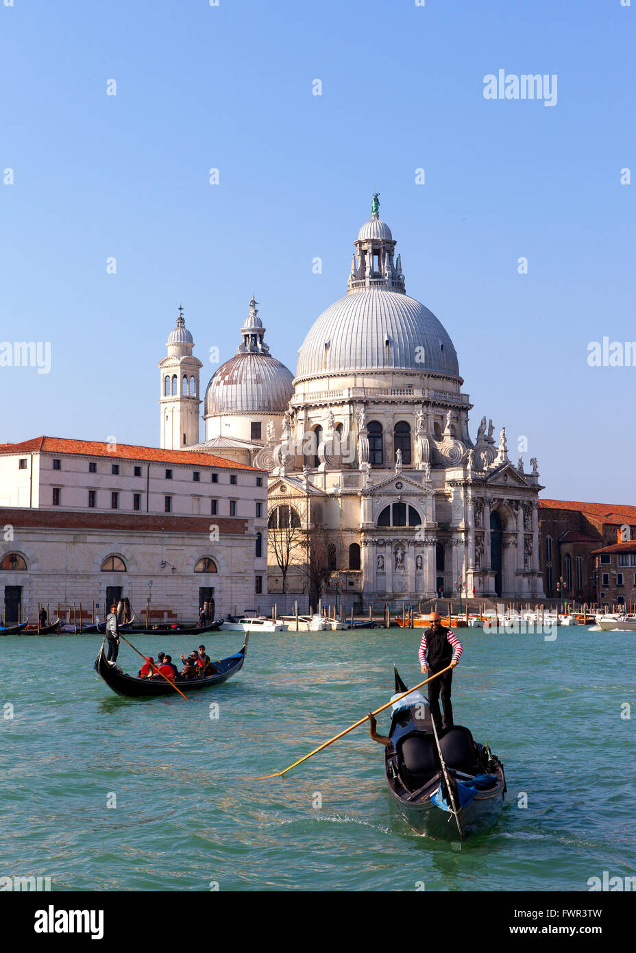 Gondoliers et Gondole à Venise grand canal avec la basilique Santa Maria della Salute en arrière-plan Banque D'Images