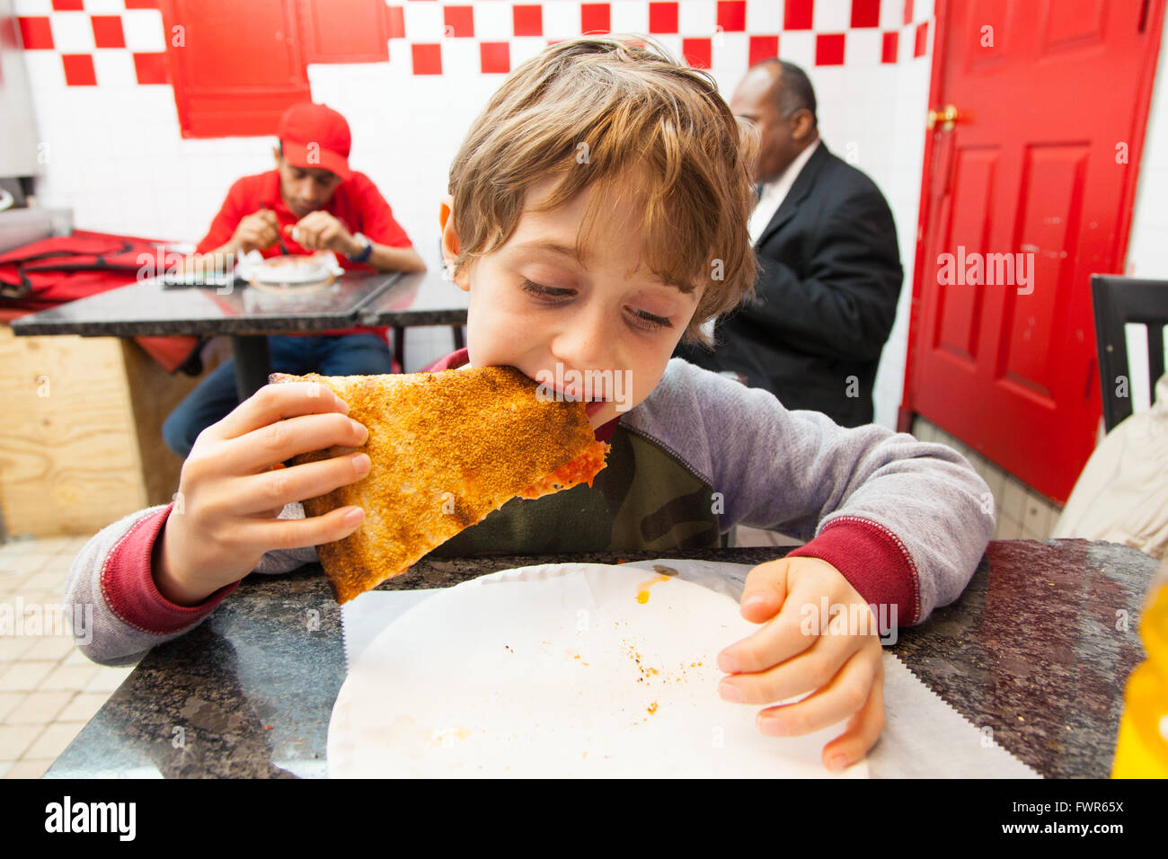 Six ans de manger une pointe de pizza pizzeria Little Italy, Manhattan, New York City, États-Unis d'Amérique. Banque D'Images