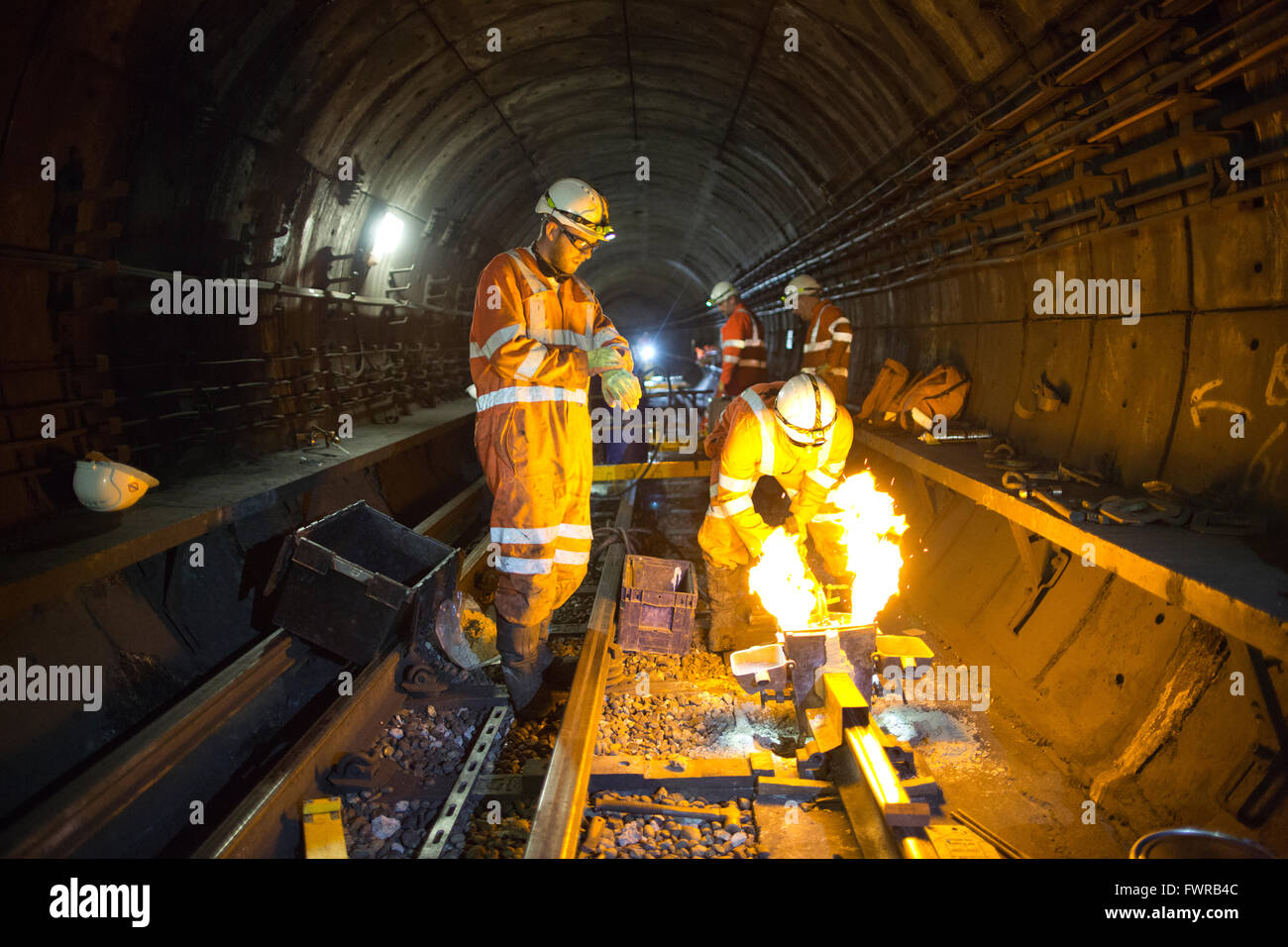 Souder les composants de la voie de remplacement ingénieurs ensemble à l'aide de soudure aluminothermique sur London Underground rail track, Londres, UK Banque D'Images