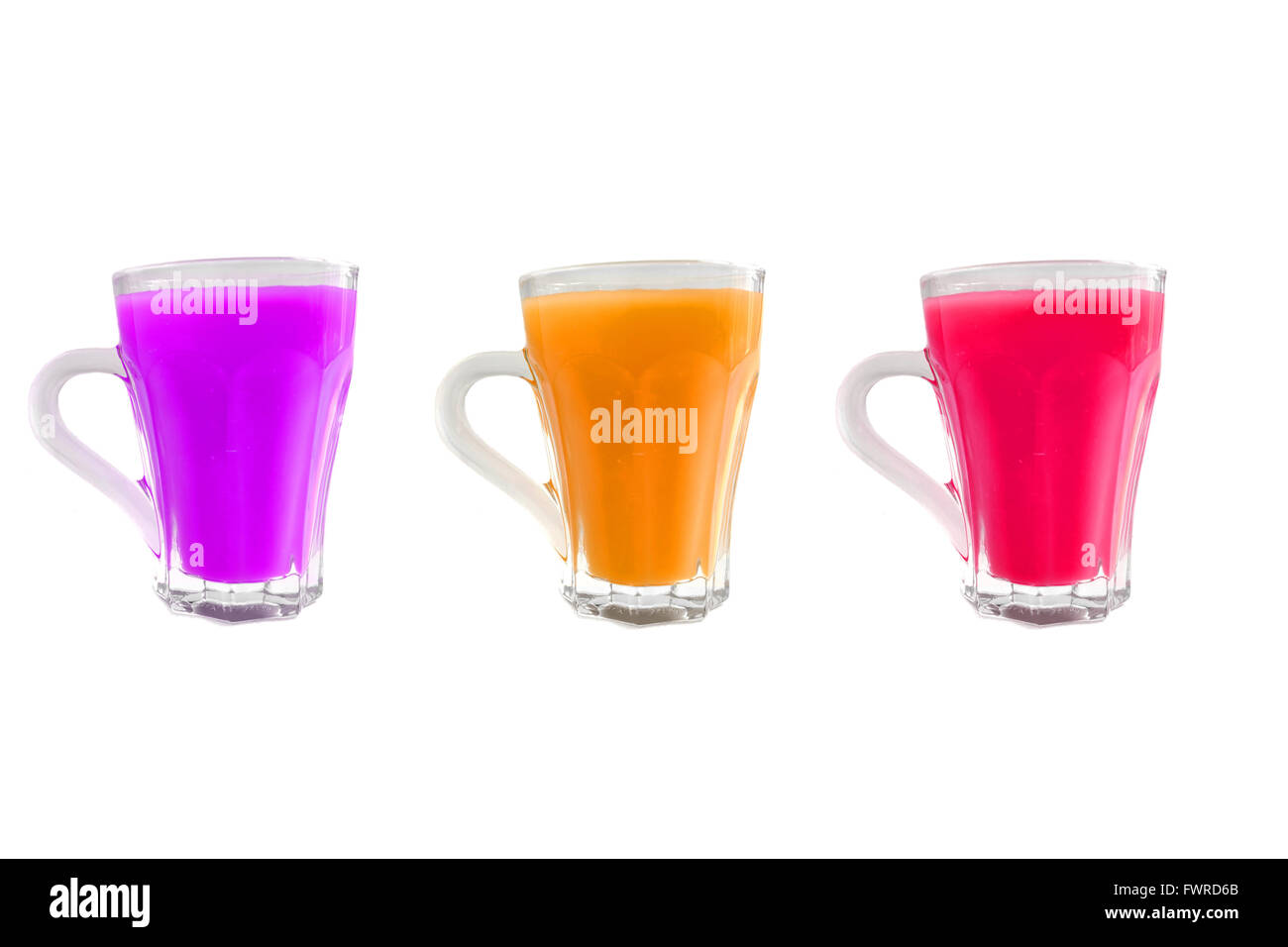 Trois tasses en verre avec des liquides de différentes couleurs en eux photographiés sur un fond blanc. Banque D'Images