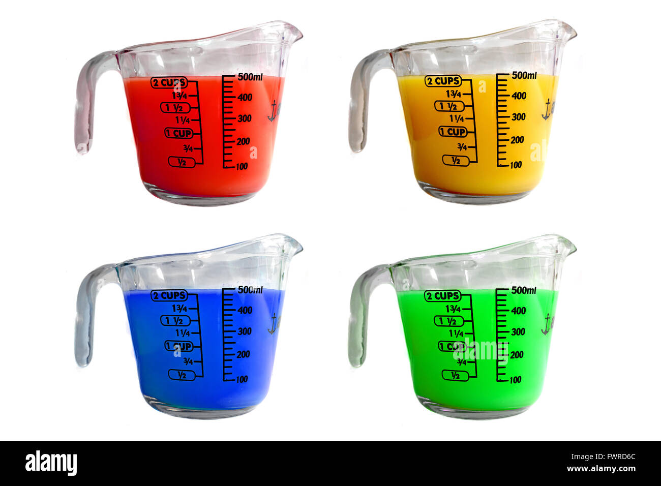 La mesure de quatre pichets remplis de liquides colorés différents photographiés sur un fond blanc. Banque D'Images