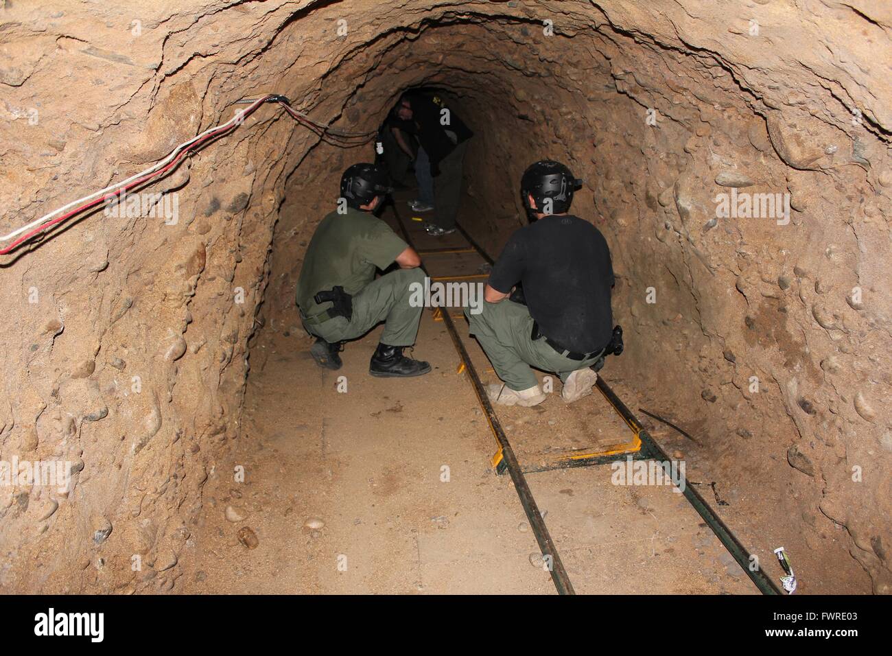 Les agents de la patrouille frontalière américaine examiner un tunnel utilisé pour les opérations de contrebande, entre Tijuana et San Diego le 29 novembre 2011 à Otay Mesa, en Californie. Le tunnel est un demi-mile de long et comportait la ventilation, l'éclairage et un système ferroviaire capable de déplacer des tonnes de marijuana enveloppés de l'autre côté de la frontière. Banque D'Images