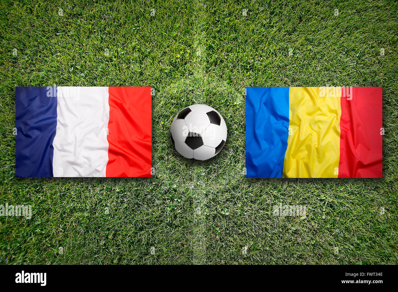 France vs Roumanie Les drapeaux sur le terrain de soccer vert Banque D'Images