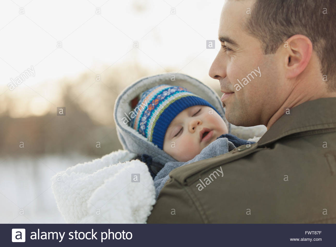Man carrying baby boy outdoors in winter Banque D'Images