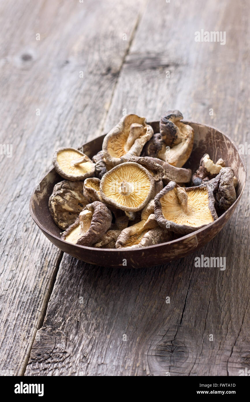 Shiitake séchés dans un bol sur un fond de bois Banque D'Images