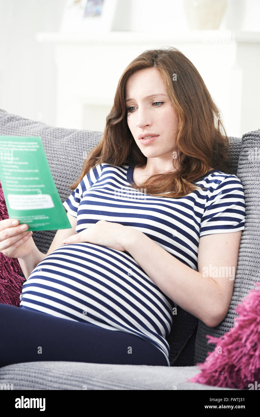 Concerné Pregnant Woman Reading notice avec les conseils d'un médecin Banque D'Images