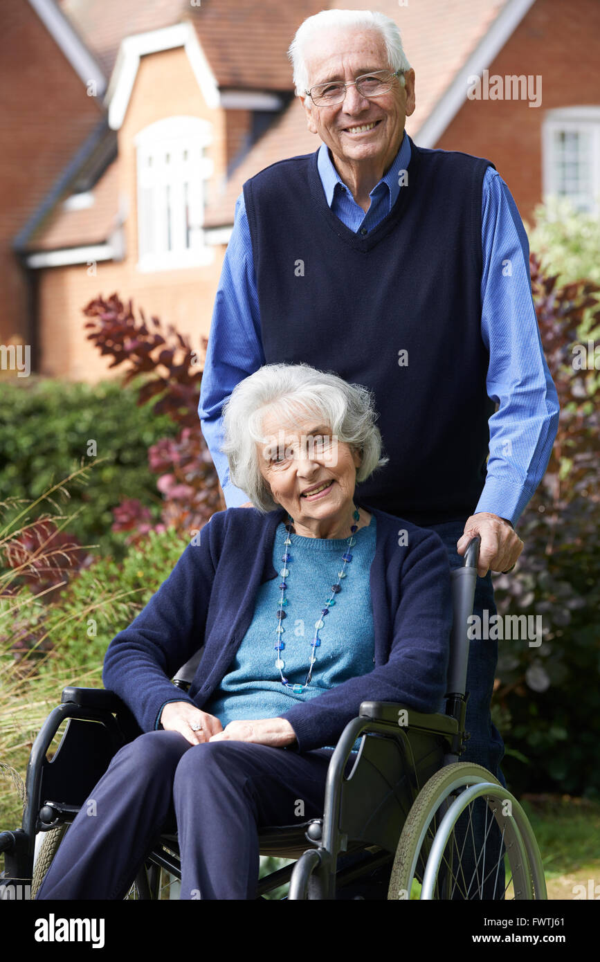 Senior Woman in Wheelchair poussés par mari Banque D'Images