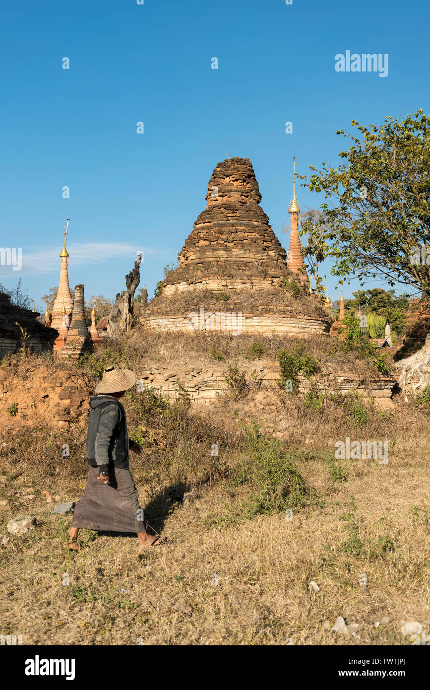 Homme marche par effritement temple (stupa) dans Sankar près du lac Inle, en Birmanie (Myanmar) Banque D'Images