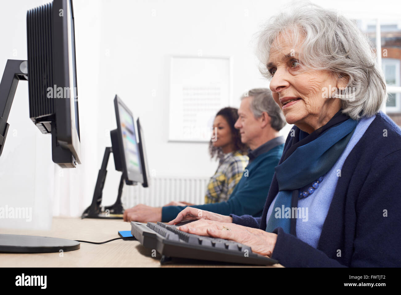 Femme Senior Assistant à Computer Class Banque D'Images