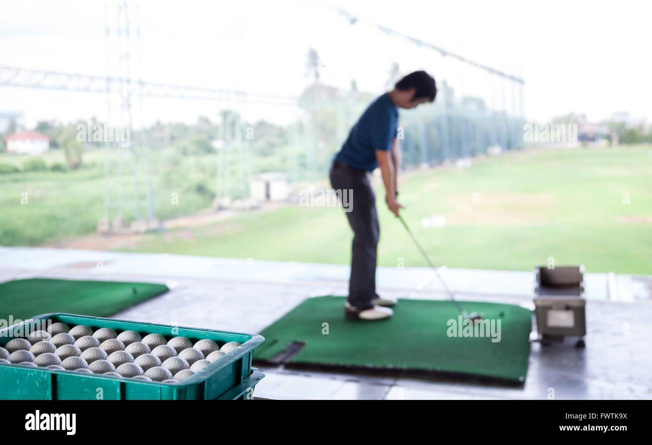 Jeune homme golfeur pratique de sa route (Selective Focus au bac d'une balle de golf) Banque D'Images