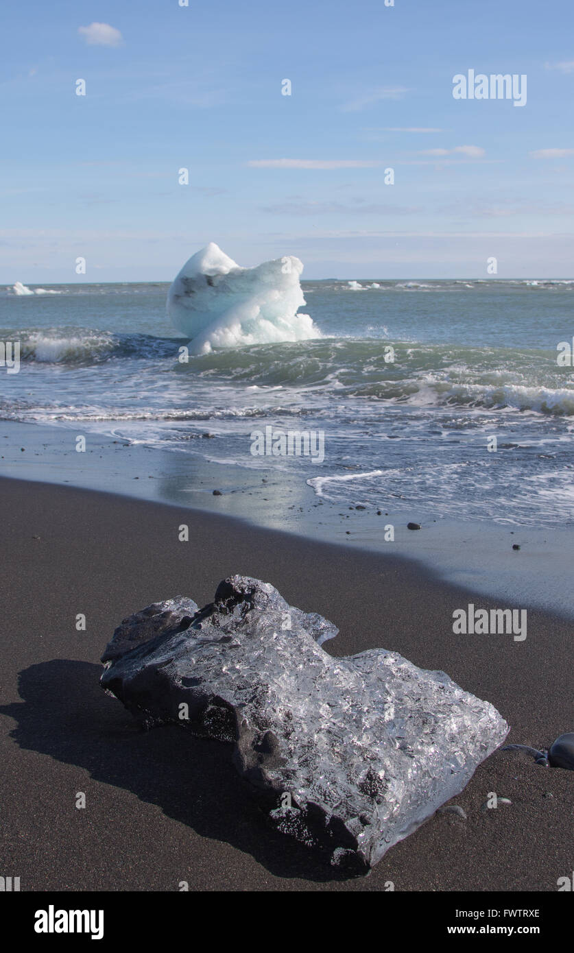 Des morceaux de glace de glacier volcanique sur une plage de lave sur l'Islande Banque D'Images