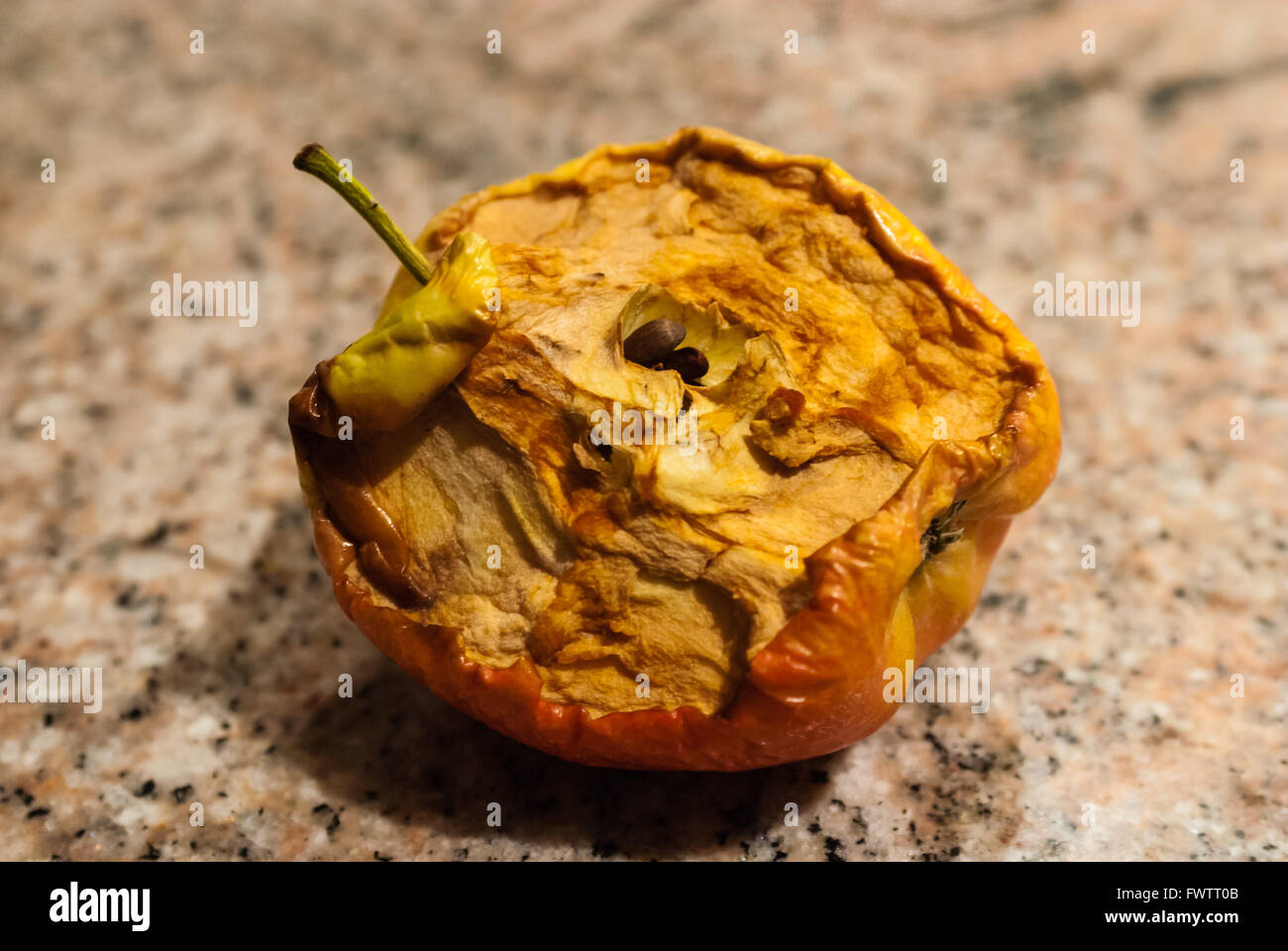 Pommes séchées mangées à moitié sur fond de granit. Banque D'Images