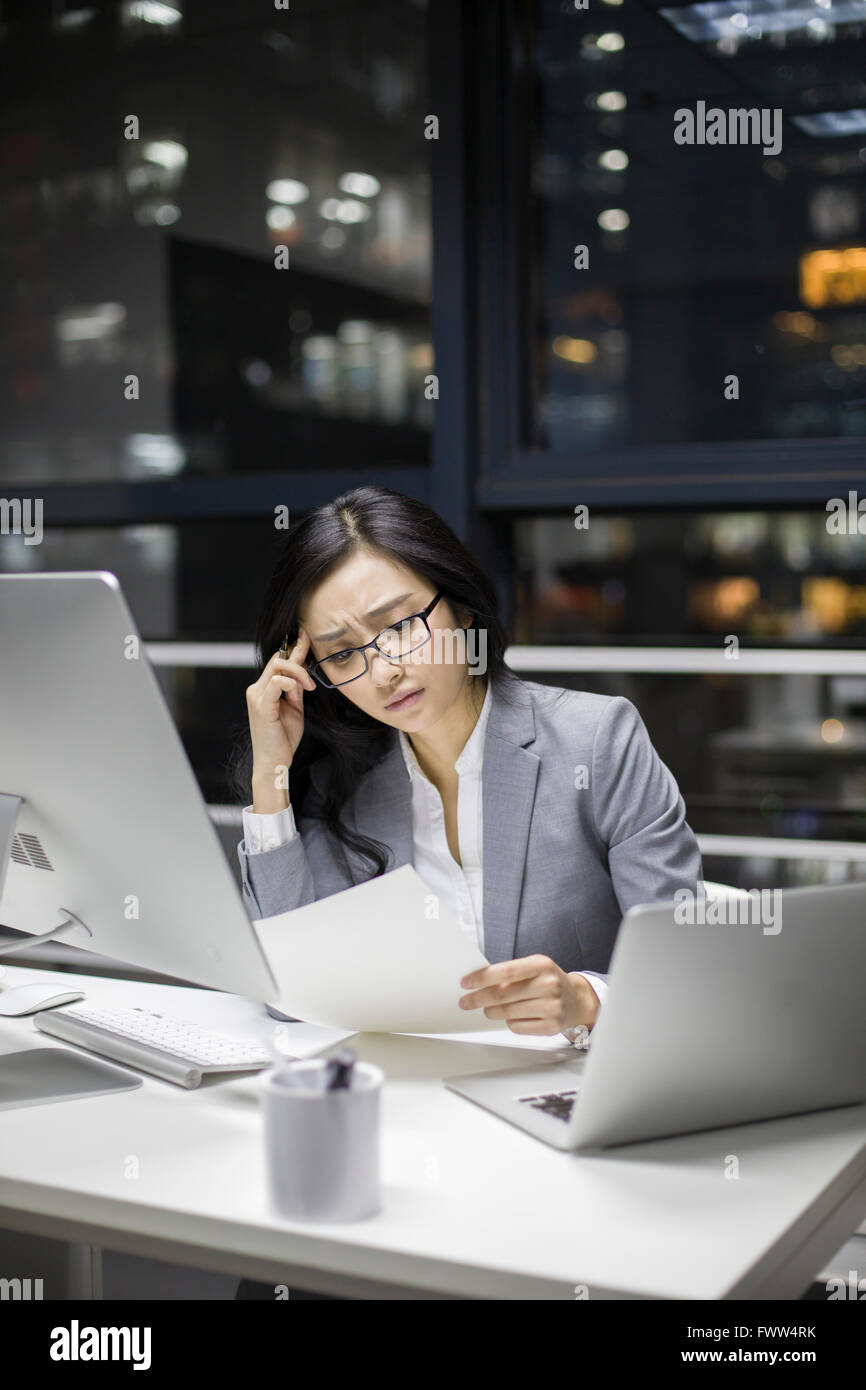 Businesswoman working in office tardif Banque D'Images