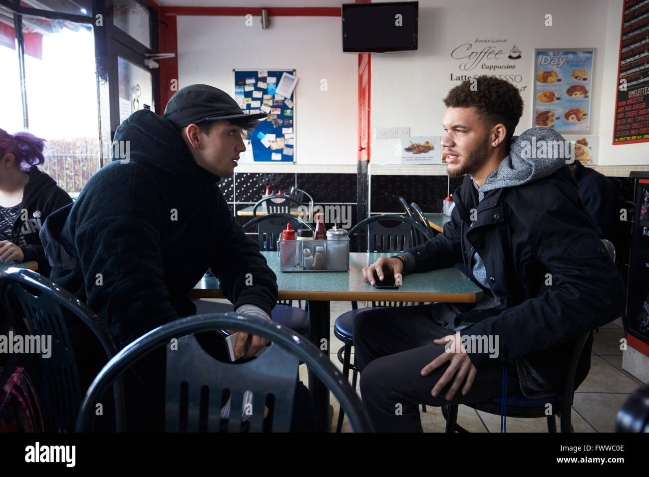 Deux étudiants hommes manger repas au Café Banque D'Images