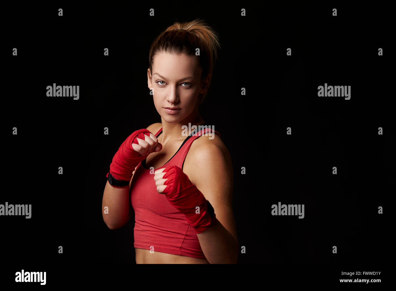 Femme en position de combat, les poings enveloppé pour la boxe Banque D'Images