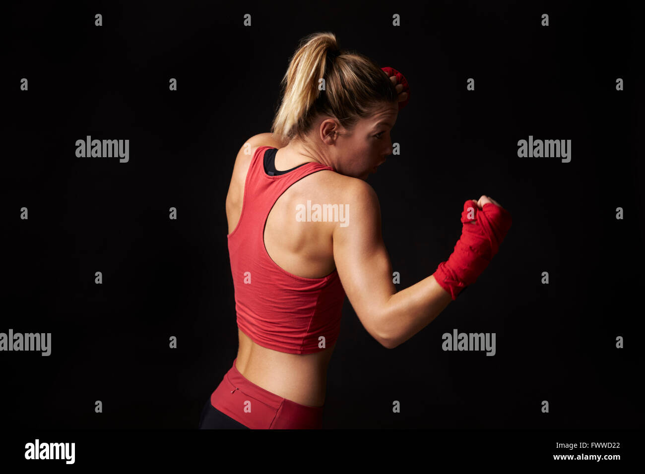Vue latérale du jeune femme shadow boxing de poing enveloppé Banque D'Images