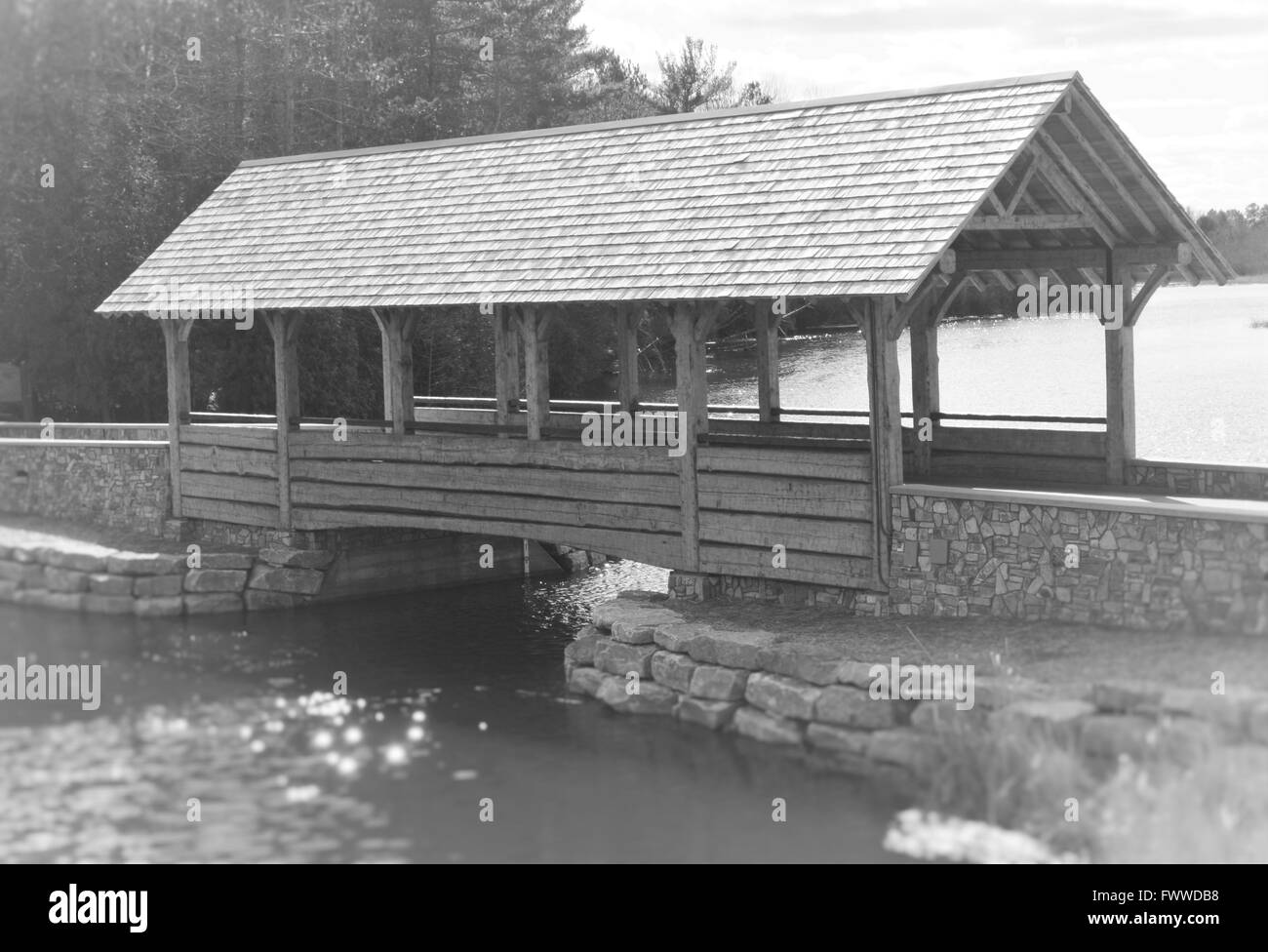 Un vieux pont couvert en bois sur une rivière calme au printemps Banque D'Images