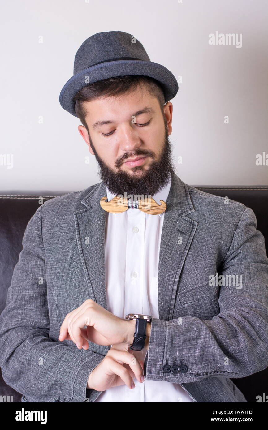 Homme barbu en costume portant un nœud papillon cheking temps Banque D'Images