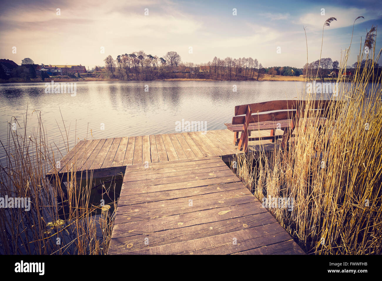 Tons Vintage image d'un banc sur l'embarcadère en bois par un lac. Banque D'Images