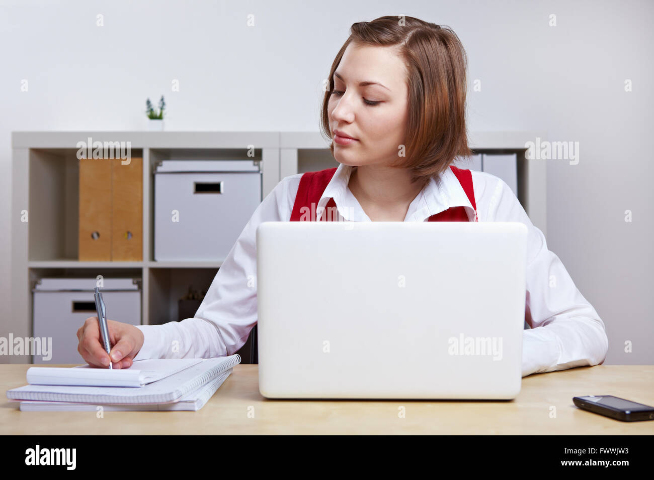 Businesswoman in office travailler à son bureau avec ordinateur portable Banque D'Images